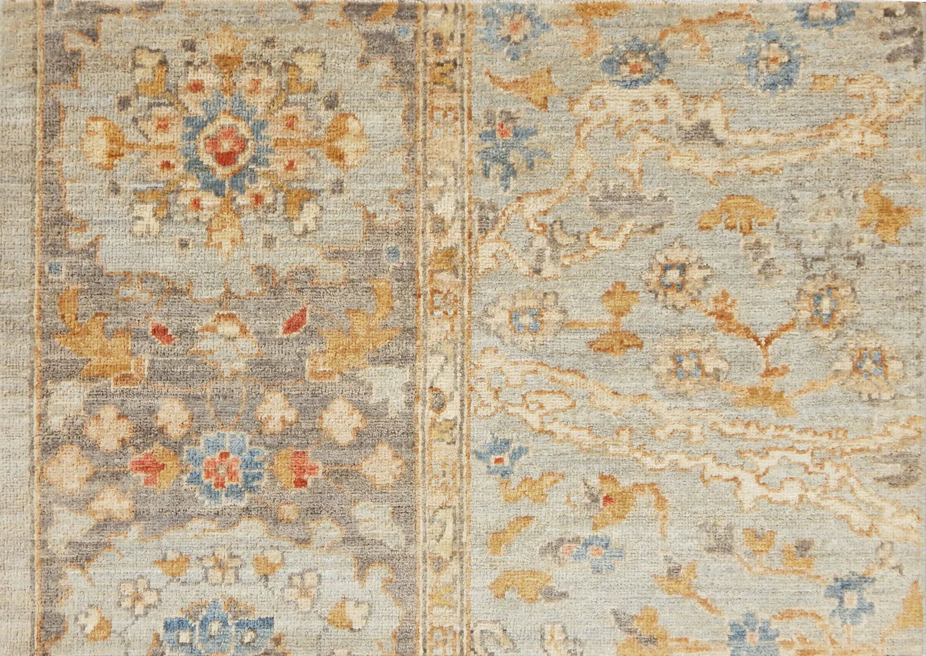 Detail of a Handknotted rug with an ornate Damascus design in blue, grey, and tan. 
