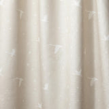 Draped fabric in a flying geese and star pattern in white on a pale ecru watercolor field.