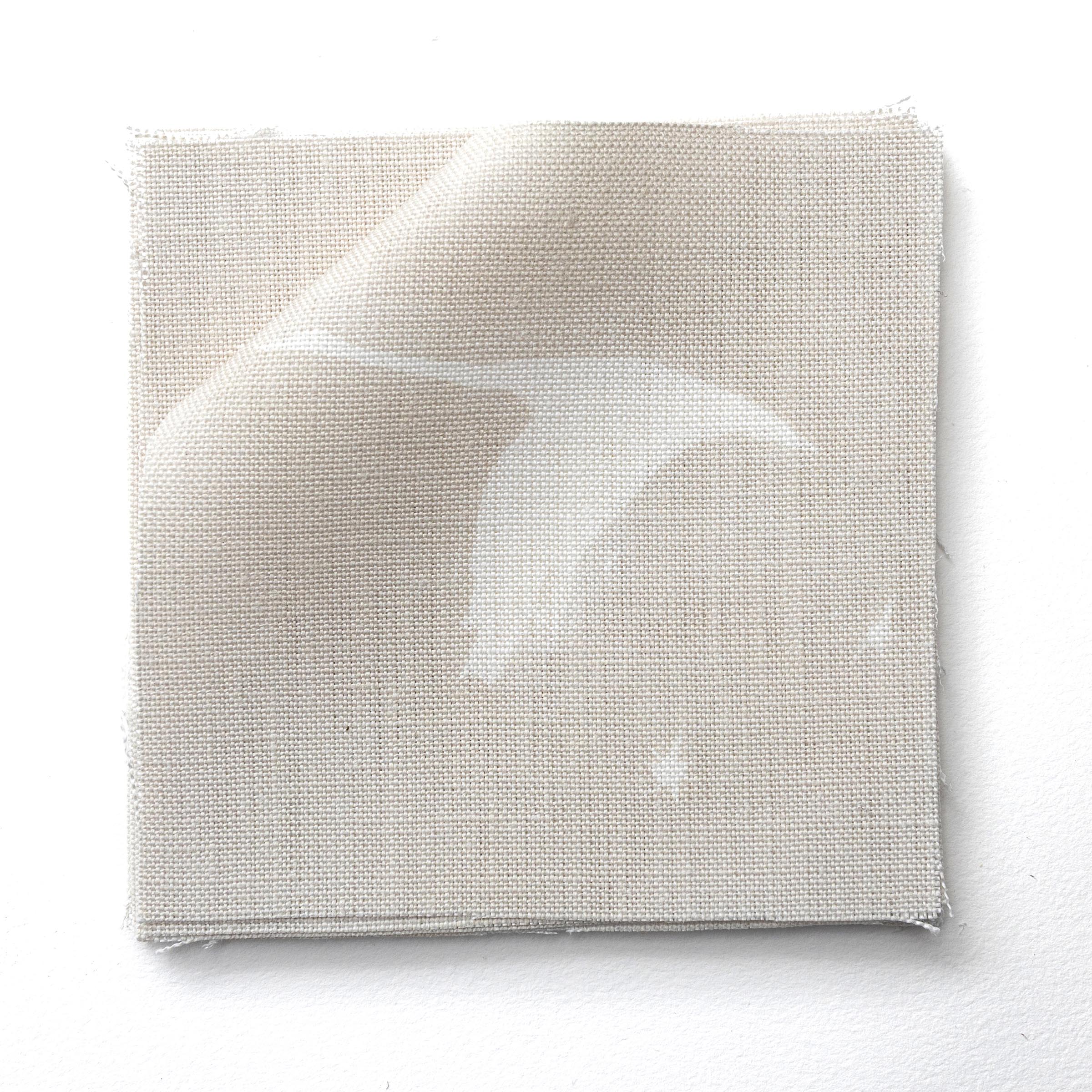 Stack of fabric swatches in a flying geese and star pattern in white on a pale ecru watercolor field.