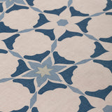 Detail of fabric in a geometric star print in shades of blue and navy on a tan field.