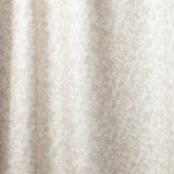 Draped fabric in a painterly branch print in white on an ecru watercolor field.