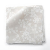 Fabric swatches in a painterly branch print in white on an ecru watercolor field.