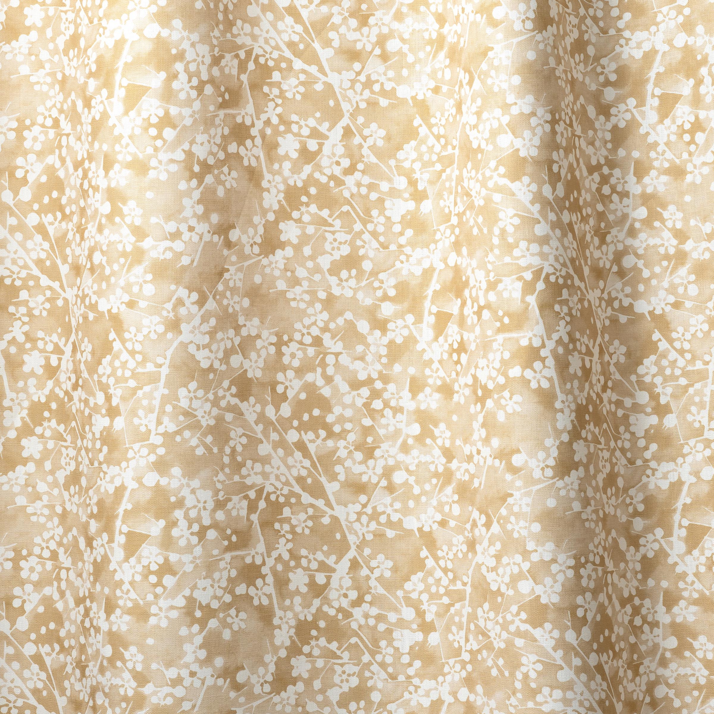 Draped fabric in a painterly branch print in white on a warm yellow watercolor field.