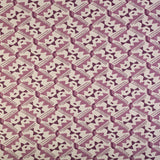 Detail of fabric in painterly diamond print in shades of purple on a white field.