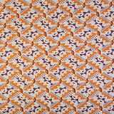 Detail of fabric in painterly diamond print in maroon and orange on a white field.
