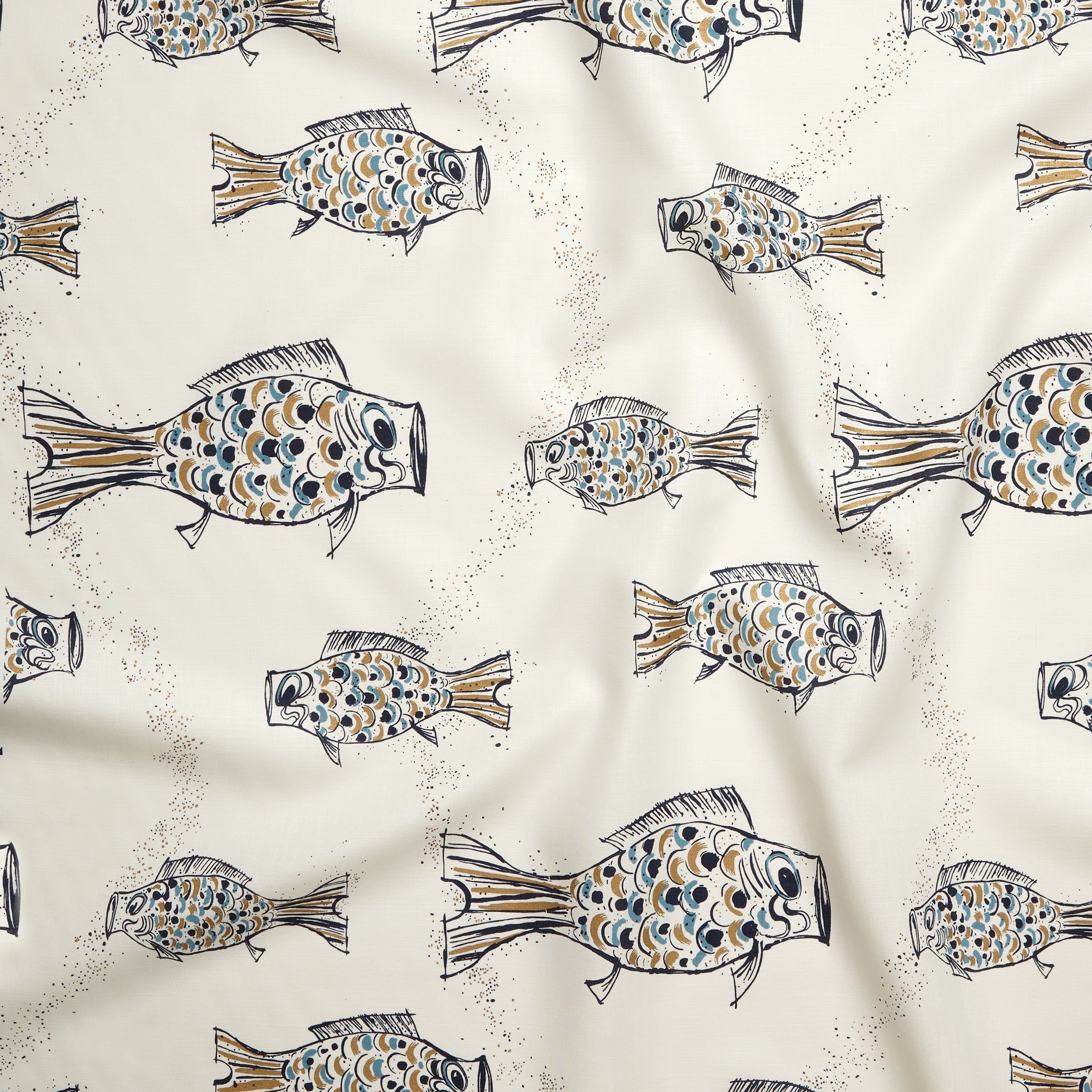 Close up of gently draped printed linen with a pattern of hand-drawn fish in navy with tan and blue scales and scattered bubble dots on white. 