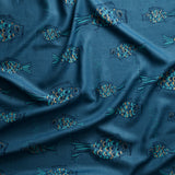 Close up of gently draped printed linen with a pattern of hand-drawn fish in navy with tan and  blue scales and scattered bubble dots on dark blue.