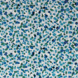 Detail of fabric in a playful polka dot print in shades of white, blue and green on a light blue field.