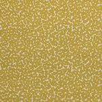Detail of fabric in a playful polka dot print in mustard on a cream field.