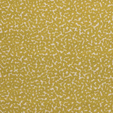 Detail of fabric in a playful polka dot print in mustard on a cream field.