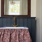 A chabby-chic sink with a ruffled fabric skirt in a playful polka dot print.
