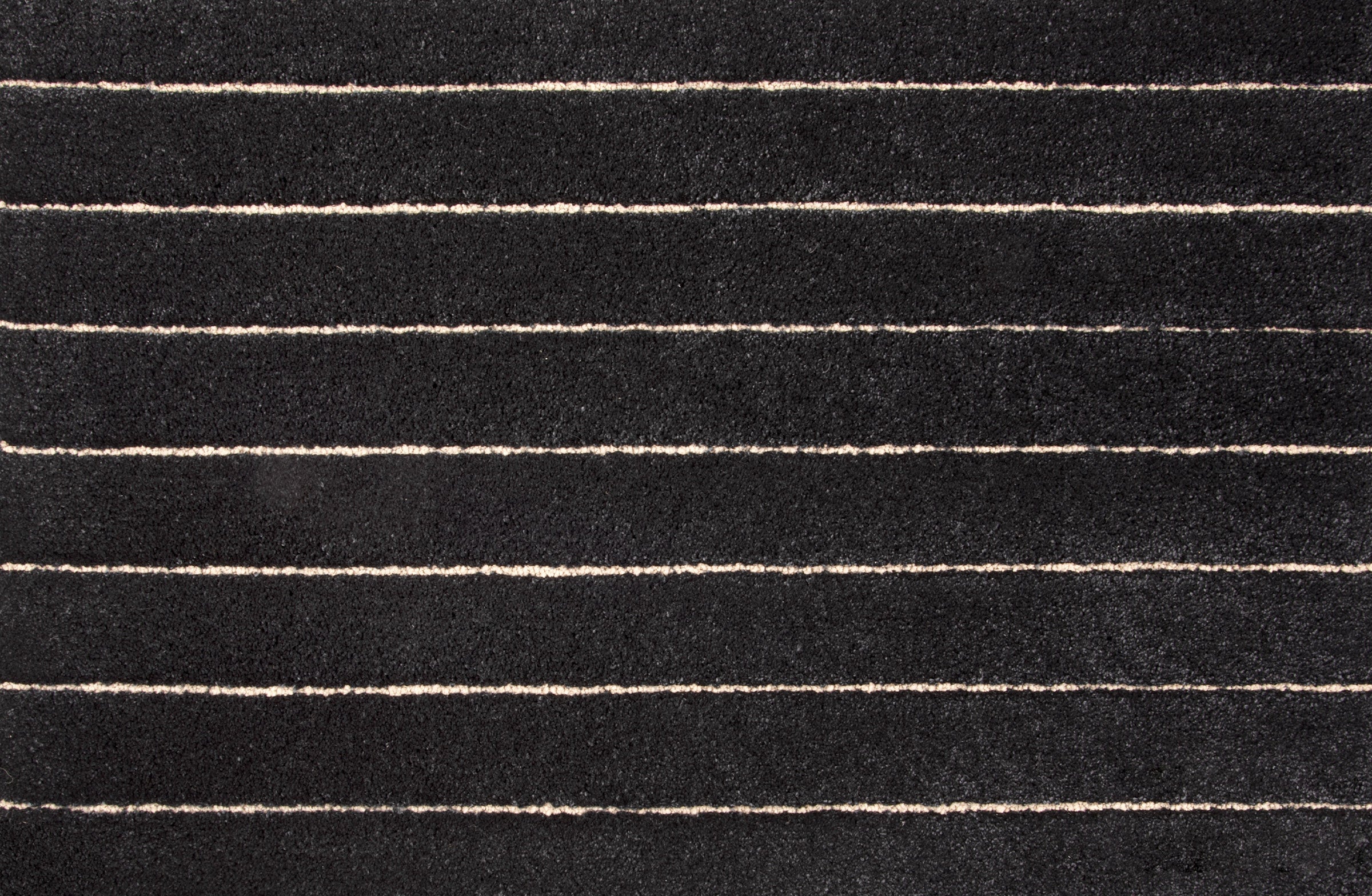 Broadloom carpet in a wide stripe pattern in dark grey and cream.