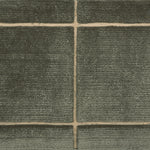 Textural performance broadloom carpet in grid design in dark green.