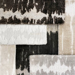 Stacked broadloom carpet samples in a contemporary abstract design in neutral colors. 