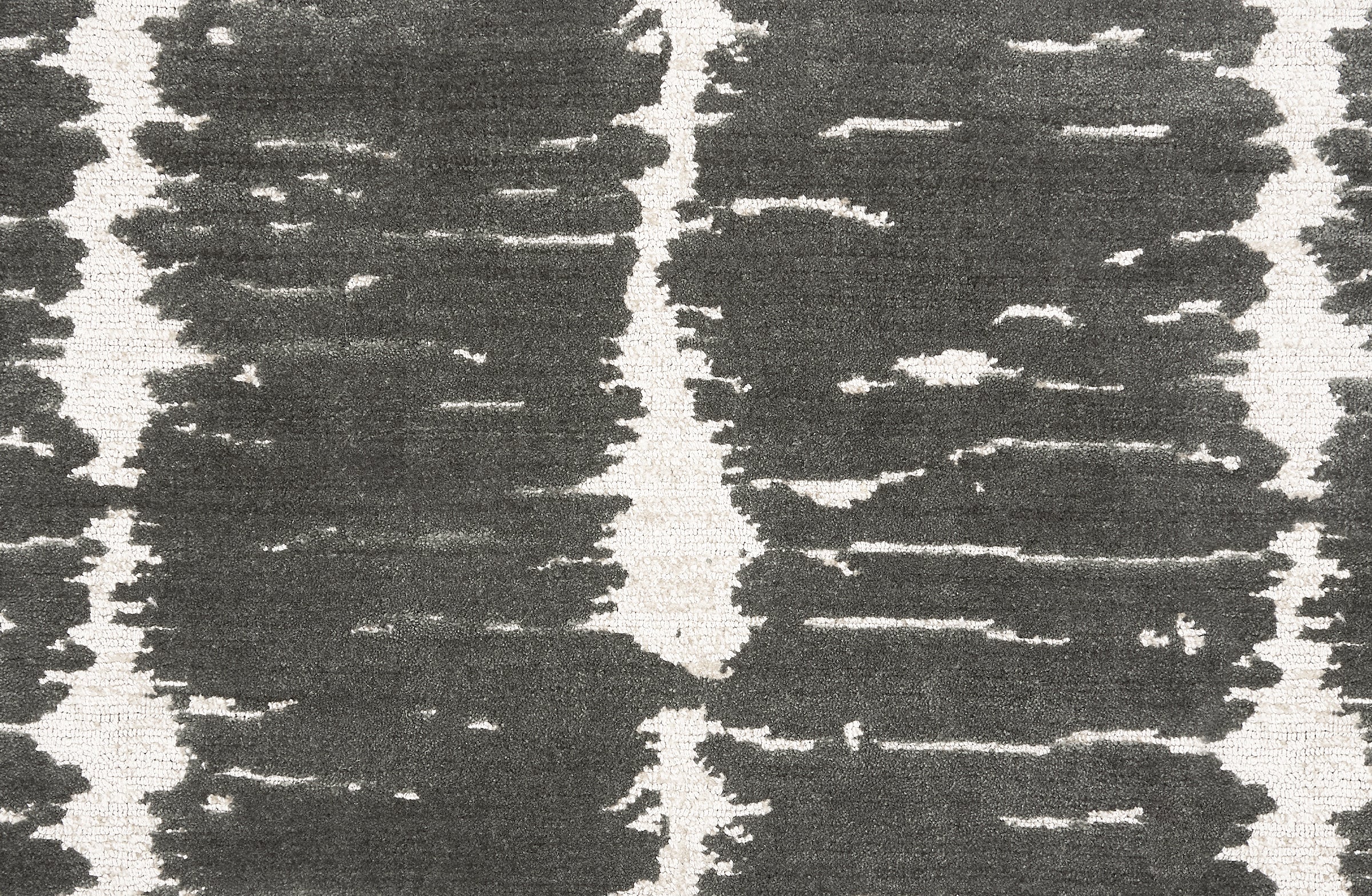 Broadloom carpet in a dimensional abstract painterly pattern in grey on a cream field.