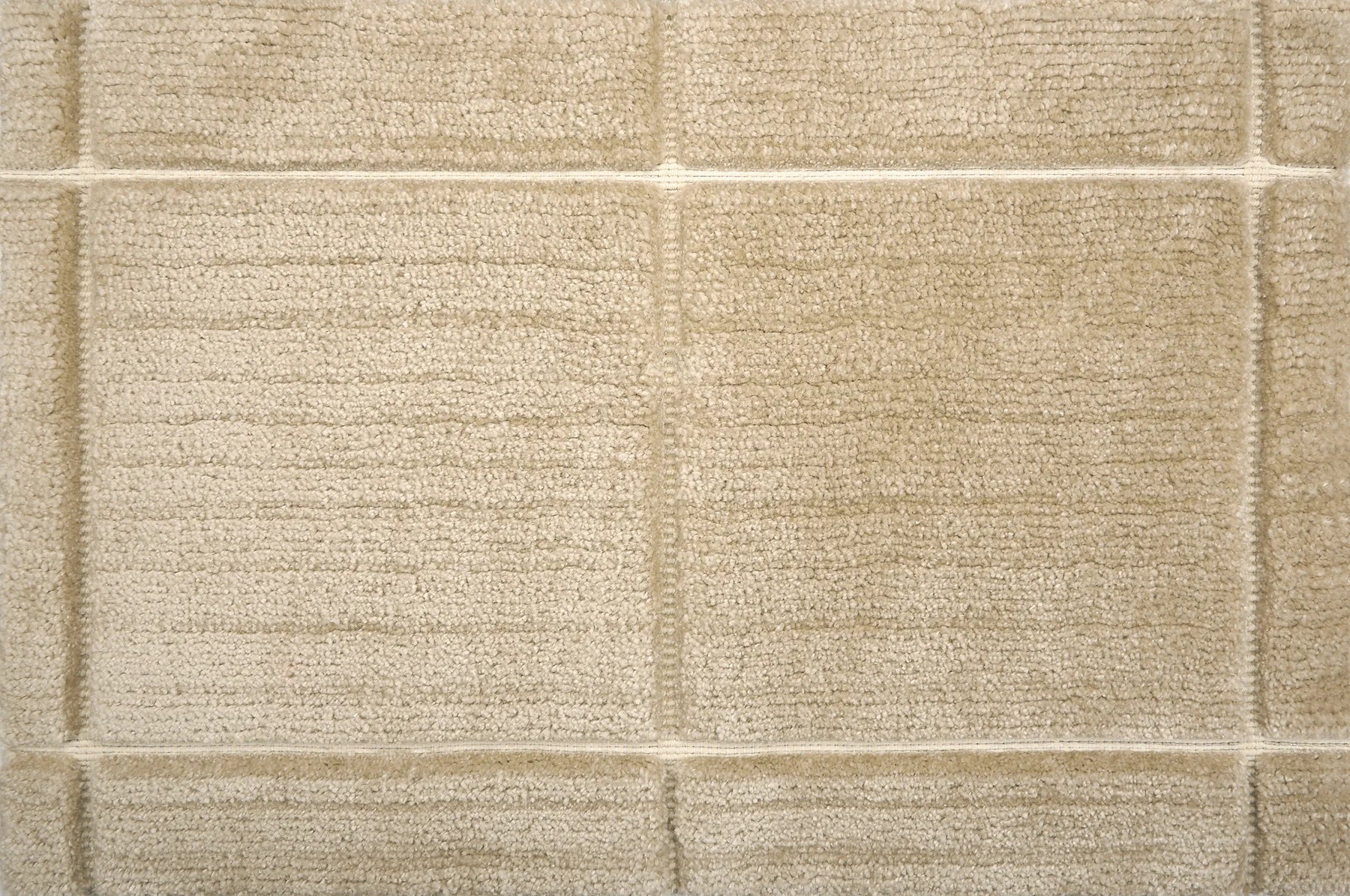 Textural performance broadloom carpet in grid design in tan.