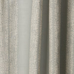 Draped printed fabric in a scrolling floral stripe pattern in cream on a light blue-gray field.