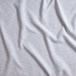 Close up of gently draped woven Indoor-Outdoor fabric with basketweave texture in white and light blue.