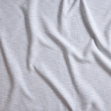 Close up of gently draped woven Indoor-Outdoor fabric with basketweave texture in white and light blue.