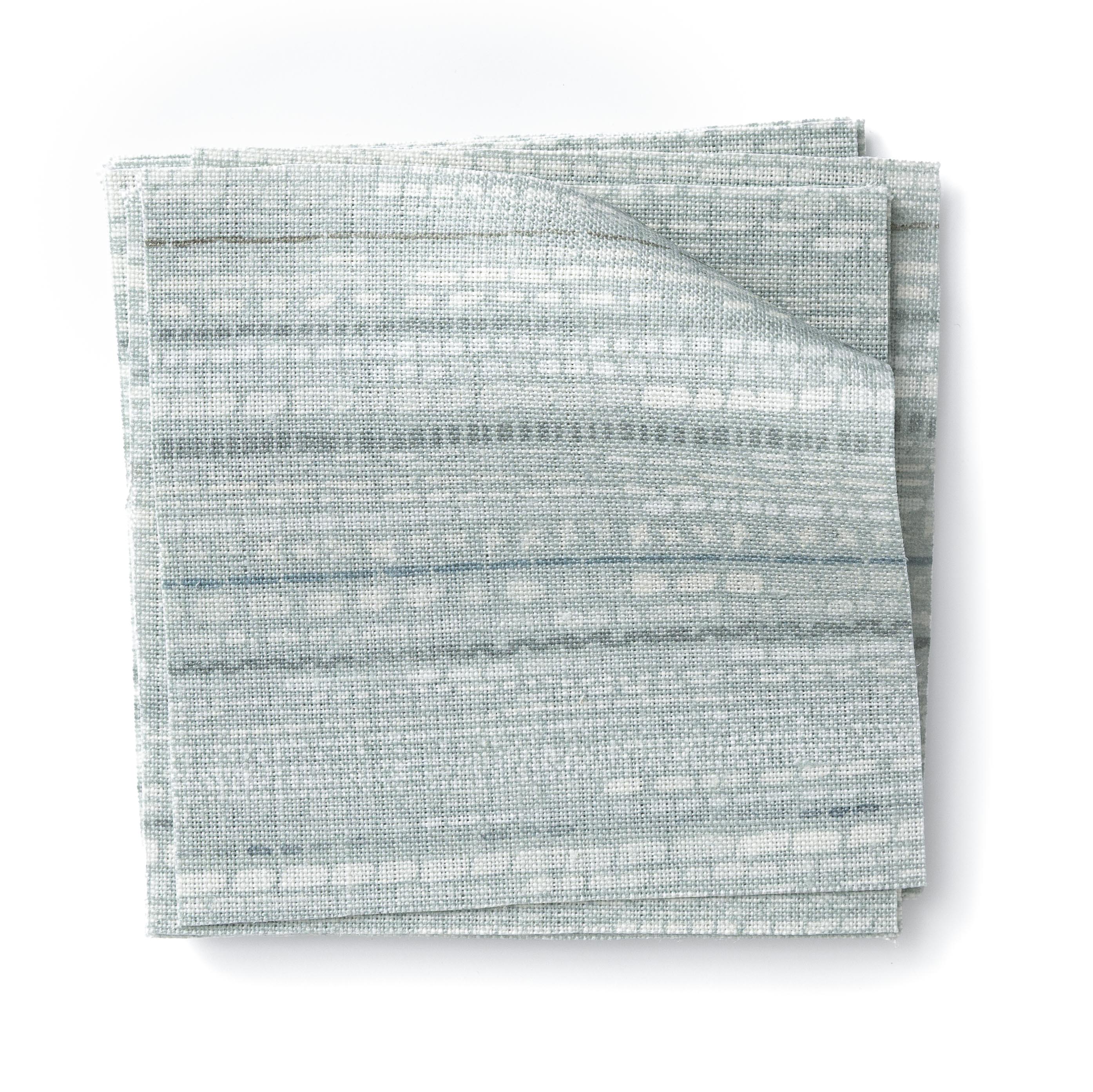 Stacked swatches of fabric in a textural striped pattern in shades of aqua blue.