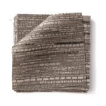 Stacks of fabric swatches textural striped pattern in shades of charcoal grey on on a white background.