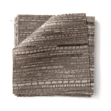 Stacks of fabric swatches textural striped pattern in shades of charcoal grey on on a white background.