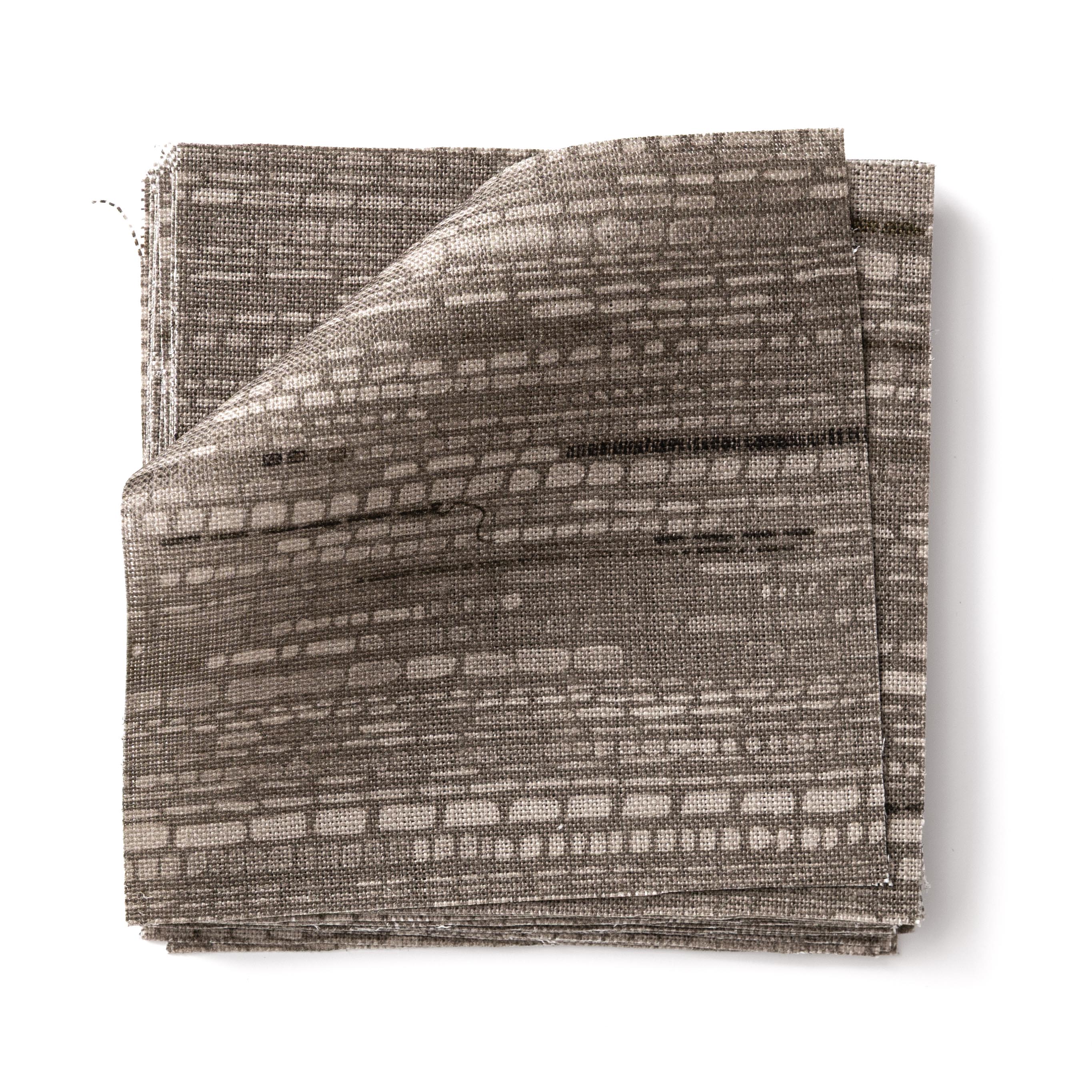 Stacks of fabric swatches textural striped pattern in shades of charcoal grey on on a white background.