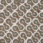 Detail of fabric in a meandering floral grid print in white and dark green on a brown field.