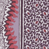 Detail of fabric in a bordered paisley print in shades of red, purple and white.