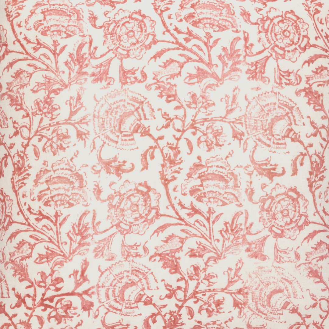Detail of fabric in a dense botanical print in red and blush on a cream field.