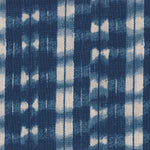 Detail of fabric in a textural shibori print in shades of navy on a greige field.