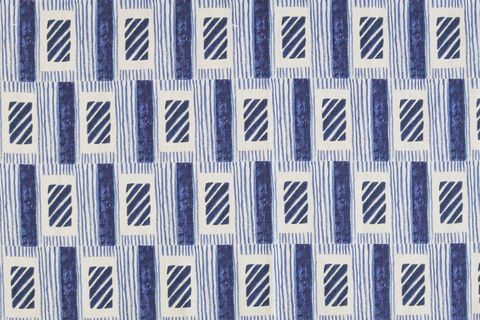 A close-up of a repeating geometric pattern featuring navy blue textured vertical bars, diagonal striped rectangles, and thin horizontal lines on a white background.