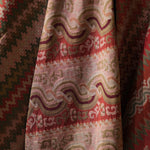 Close-up of patterned fabric with red, green, and beige colors.