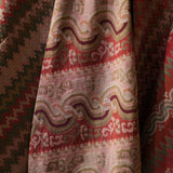 Close-up of patterned fabric with red, green, and beige colors.