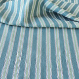 Detail of a draped hand-woven cotton striped fabric in blue, green cream and navy.