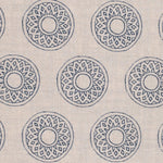 Detail of fabric in a repeating circular geometric print in navy on a cream field.