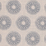 Detail of fabric in a repeating circular geometric print in navy on a cream field.