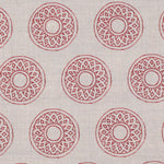 Detail of fabric in a repeating circular geometric print in red on a greige field.