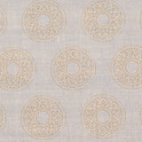Detail of fabric in a repeating circular geometric print in yellow on a greige field.