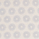 Detail of fabric in a repeating circular geometric print in light blue on a cream field.