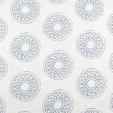 Detail of fabric in a repeating circular geometric print in gray on a white field.