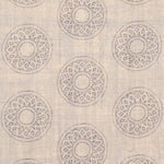 Detail of fabric in a repeating circular geometric print in light gray on a tan field.