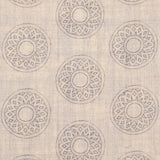 Detail of fabric in a repeating circular geometric print in light gray on a tan field.