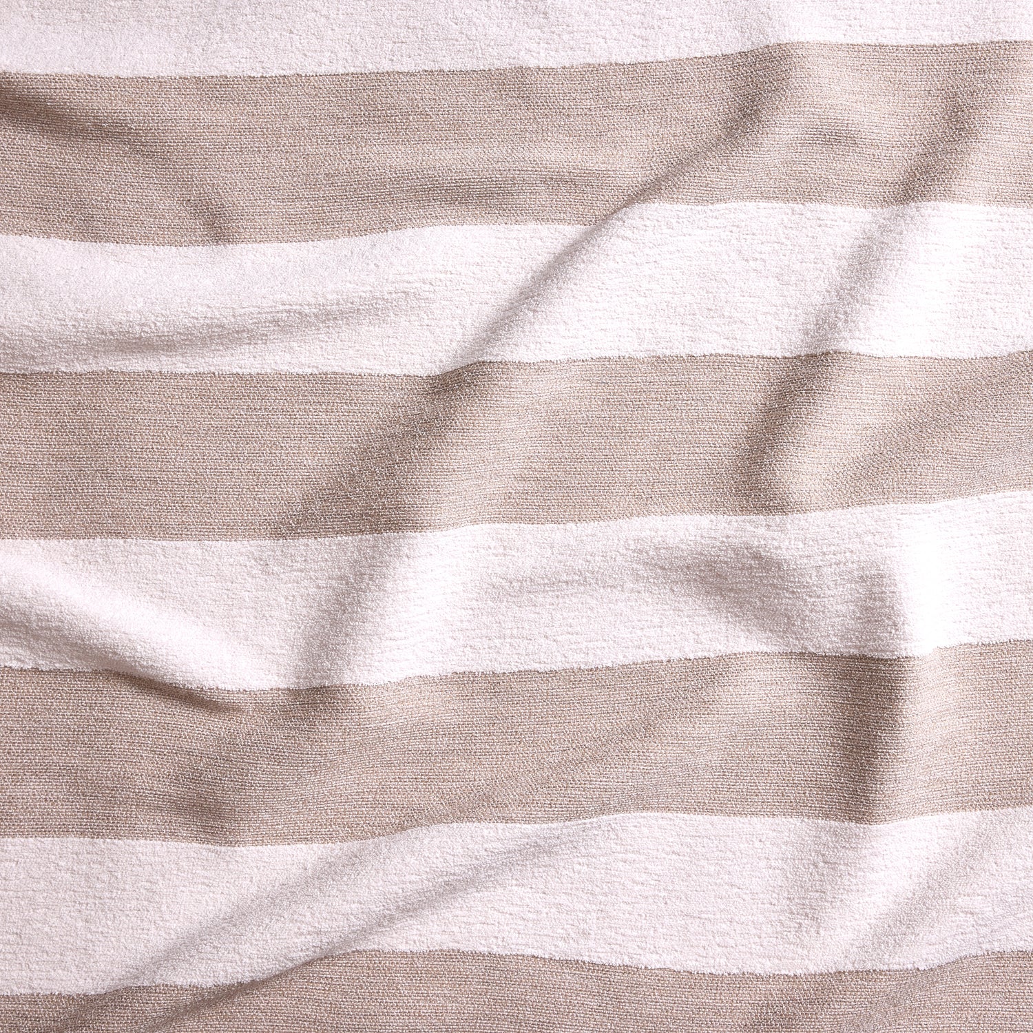 Close up of gently draped woven Indoor-Outdoor fabric with wide textural stripes in white and taupe.