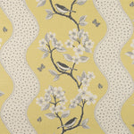 Detail of fabric in a striped bird and tree print in gray and white on a yellow field.