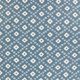 Detail of fabric in a geometric lattice print in white on a blue field.