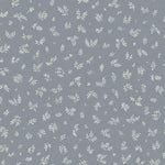 Detail of fabric in a minimal repeating leaf print in cream on a blue-gray field.
