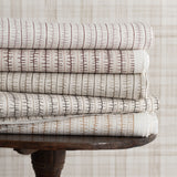 Stack of patterned fabrics on a wooden table with a neutral background