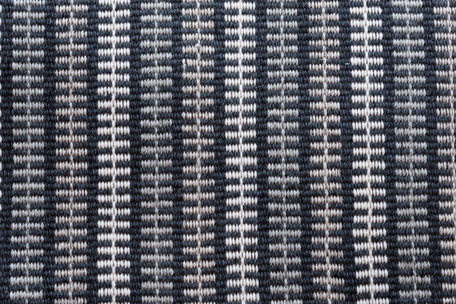 Broadloom carpet in a ticking stripe in shades of grey and white on navy. 