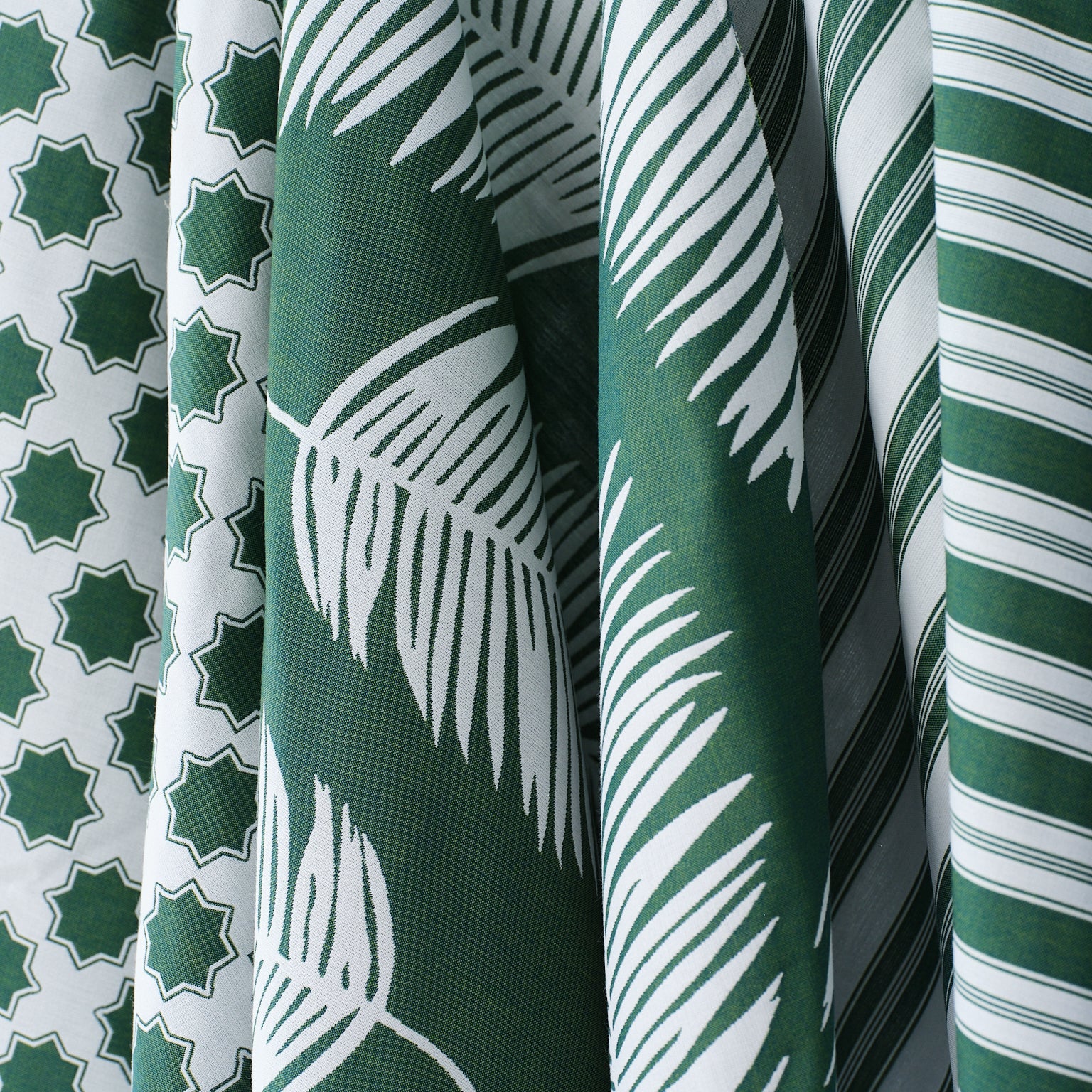 Performance fabrics in green and white in 
a palm print, moroccan star and simple stripe.